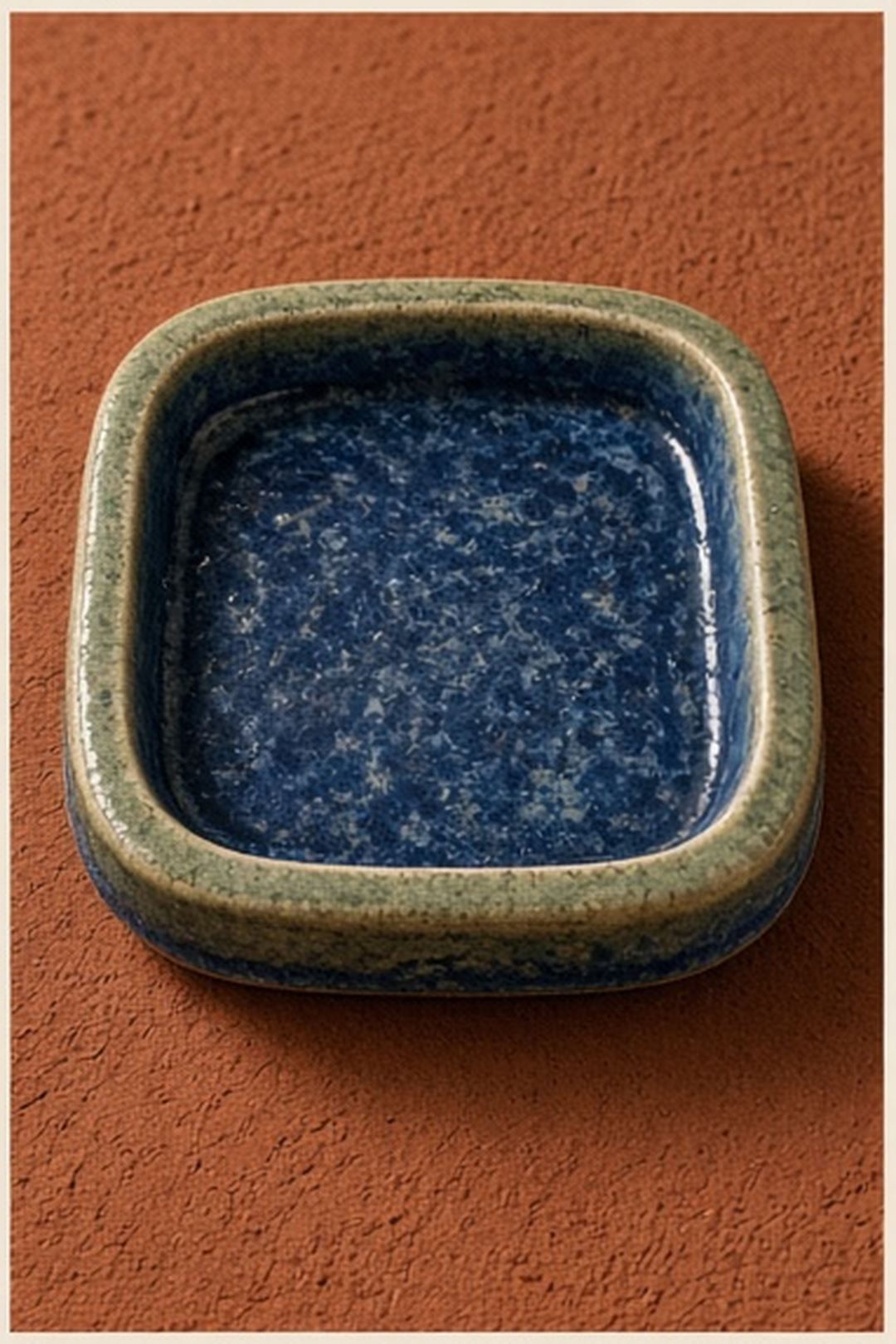 Closed glazed practice tray resting inside a local clay boundary
